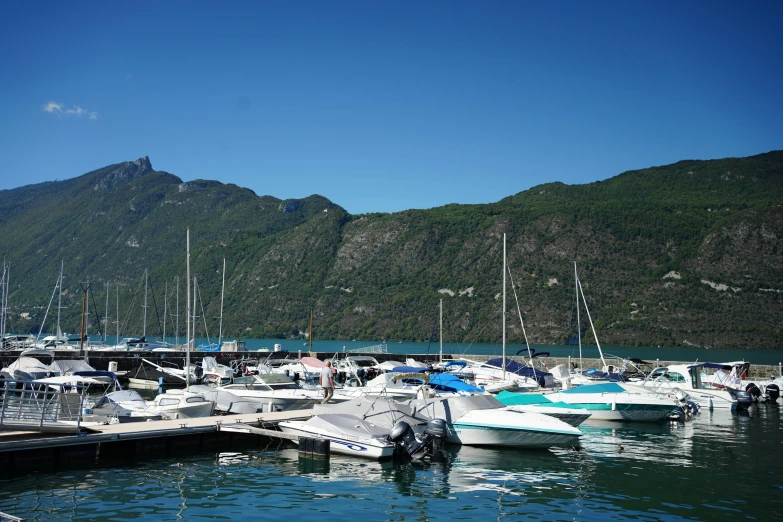 a bunch of boats that are in the water, by Terese Nielsen, pexels contest winner, mingei, fjords in background, clear blue skies, al fresco, thumbnail