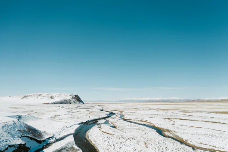 a river running through a snow covered field, unsplash contest winner, hurufiyya, clear blue skies, naranbaatar ganbold, shot on hasselblad, thumbnail