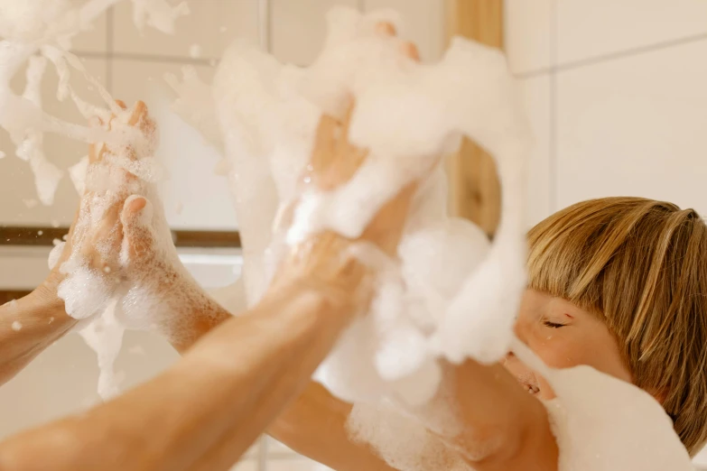 a woman and a child washing their hands in a bathtub, by Julia Pishtar, pexels, process art, fluffy body, foamy bubbles, lachlan bailey, carefully crafted