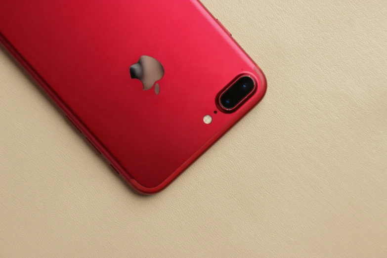 a red iphone sitting on top of a table, by Romain brook, pexels, photorealism, metallic red, cover shot, back camera, ( ultra realistic