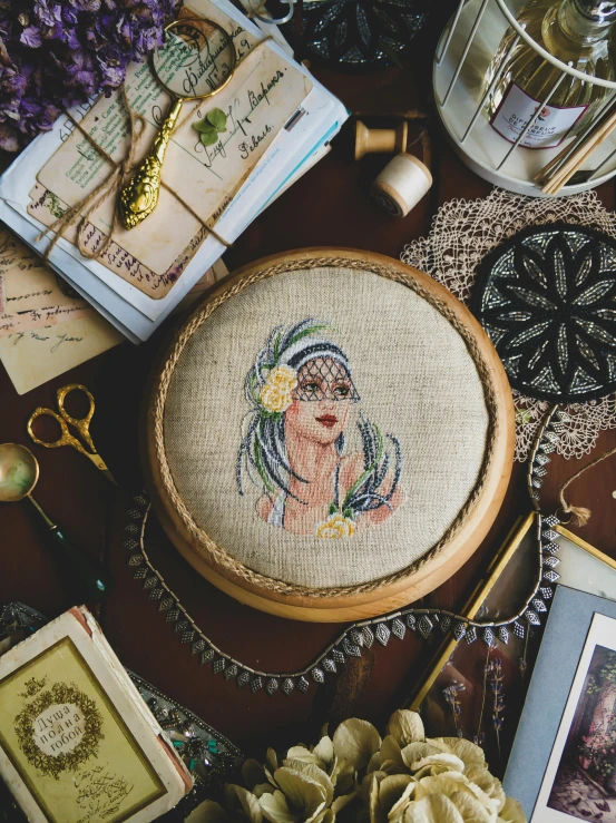 a cross stitch picture sitting on top of a table, inspired by Clara Weaver Parrish, trending on pexels, arts and crafts movement, golden halo behind her head, arabian beauty, flatlay, closeup portrait of an artificer