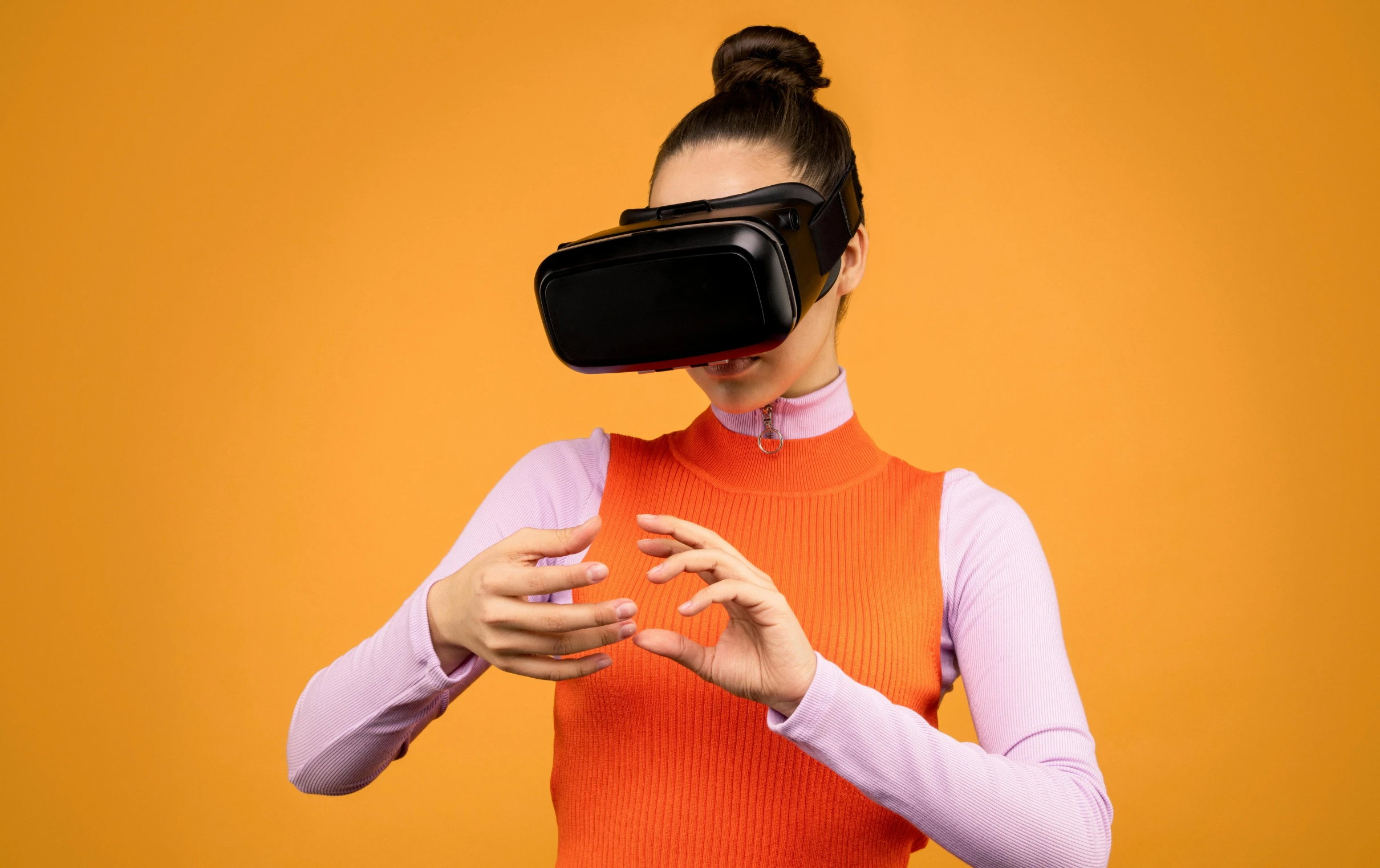 a woman using a virtual reality headset on an orange background, by Joe Bowler, pexels, model is wearing techtical vest, 🦩🪐🐞👩🏻🦳, sleek hands, advertising photo