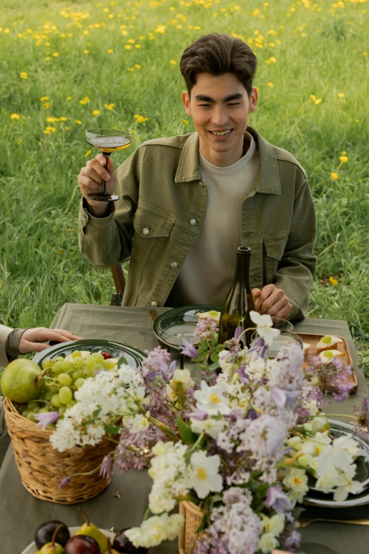 a man and a woman sitting at a picnic table, inspired by Konstantin Somov, pexels contest winner, renaissance, standing in a field with flowers, drinking champagne, asian man, andrew garfield