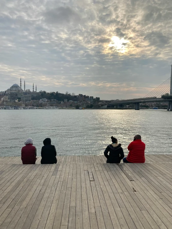 a group of people sitting on a dock next to a body of water, hurufiyya, fallout style istanbul, profile image