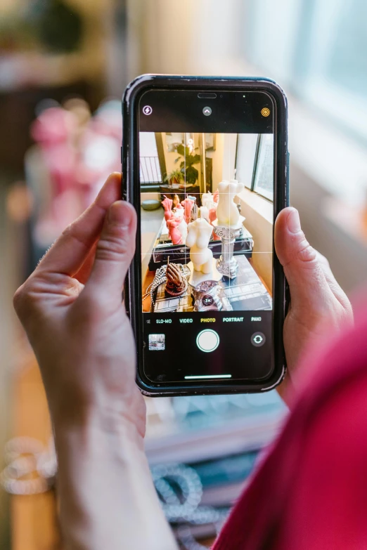 a person taking a picture with a cell phone, standing in a restaurant, colorful photo, ecommerce photograph, f / 2 0
