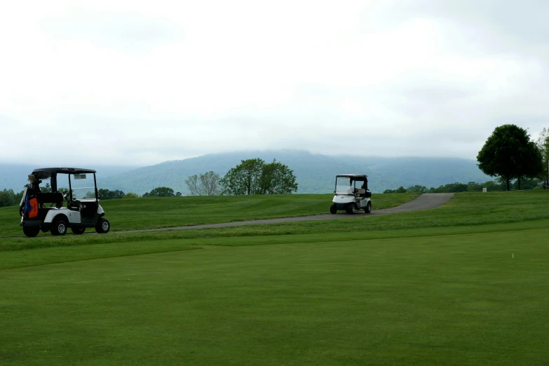 two golf carts on a golf course with mountains in the background, flickr, mingei, chesterfield, thumbnail, slight overcast weather, cornell