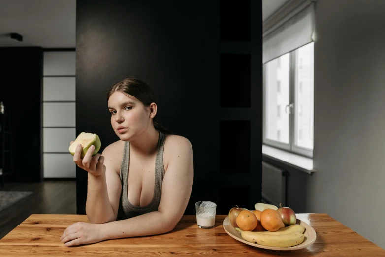 a woman sitting at a table eating a banana, inspired by Elsa Bleda, pexels contest winner, renaissance, buxom chested, teenage girl, wearing a low cut tanktop, nikolay georgiev