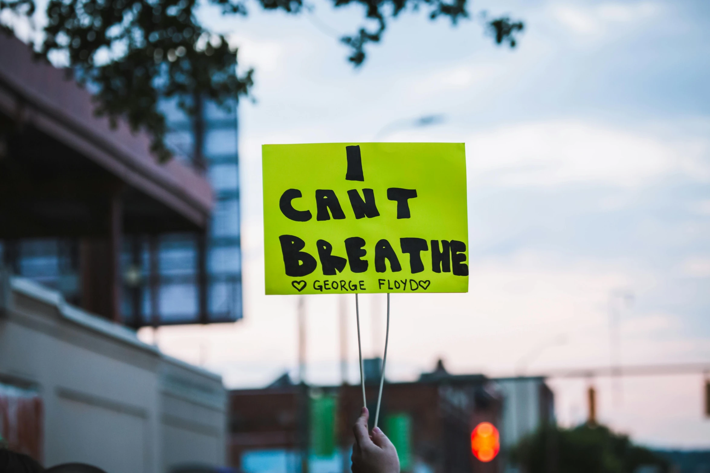 a person holding a sign that says i can't breathe, by Carey Morris, trending on unsplash, float, light bleed, album cover, neighborhood