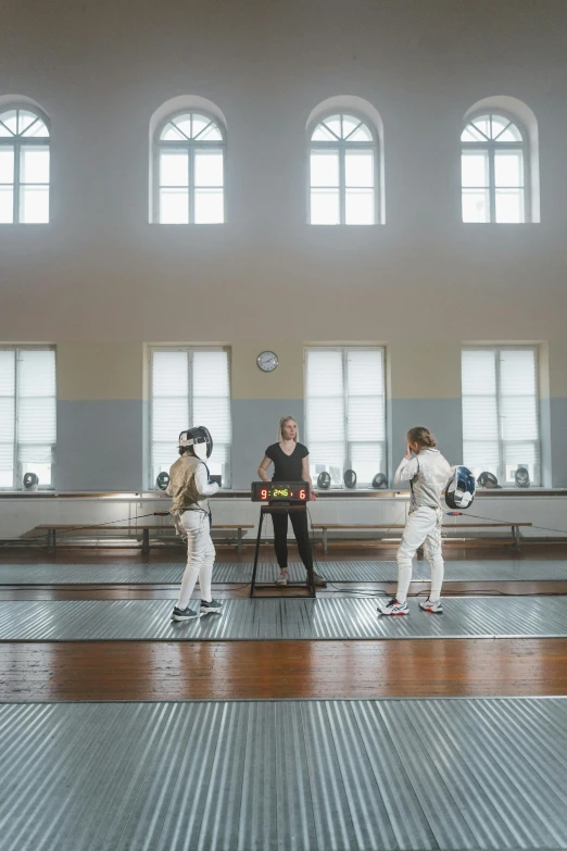 a group of people standing on top of a wooden floor, fencing, university, stefan koidl, high-quality photo