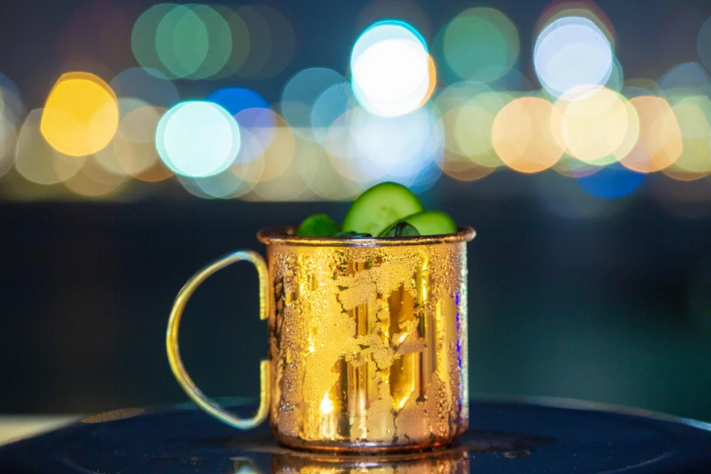 a copper mug with a cucumber in it, unsplash, night view, shiny gold, at the waterside, mule