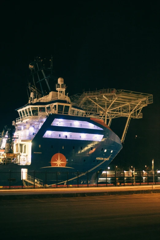 a large boat sitting on top of a body of water, busy night, at night time, at night