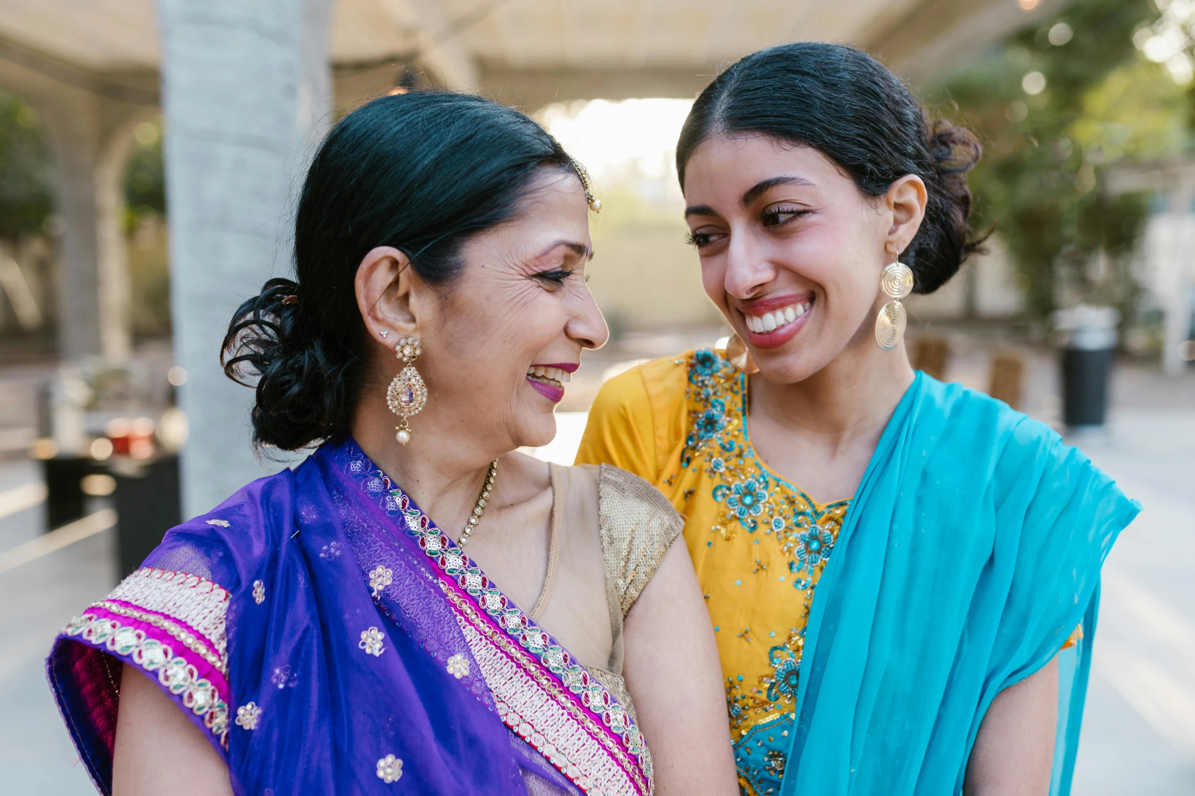 a couple of women standing next to each other, by Carey Morris, pexels contest winner, hurufiyya, dressed in a sari, wholesome, brittney lee, family friendly