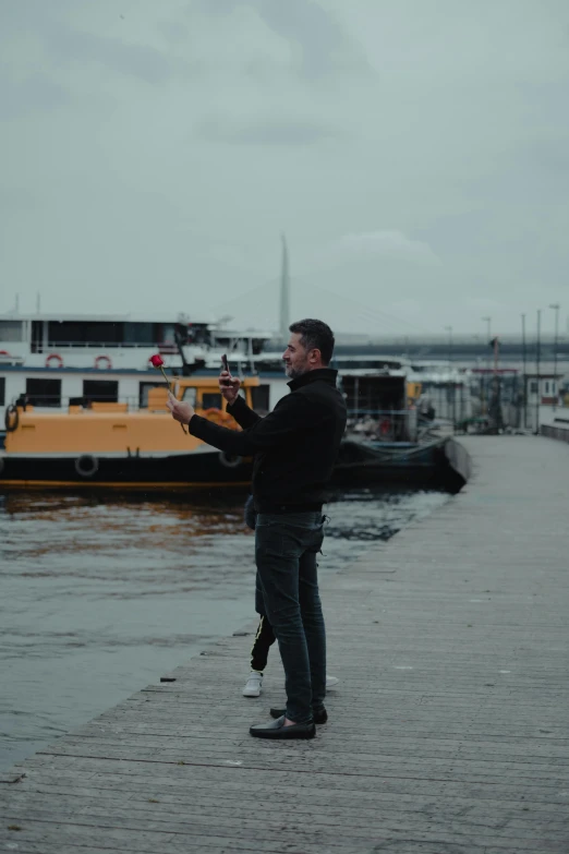 a man standing on a dock flying a kite, by Attila Meszlenyi, happening, istanbul, hq 8k cinematic, behind the scenes photo