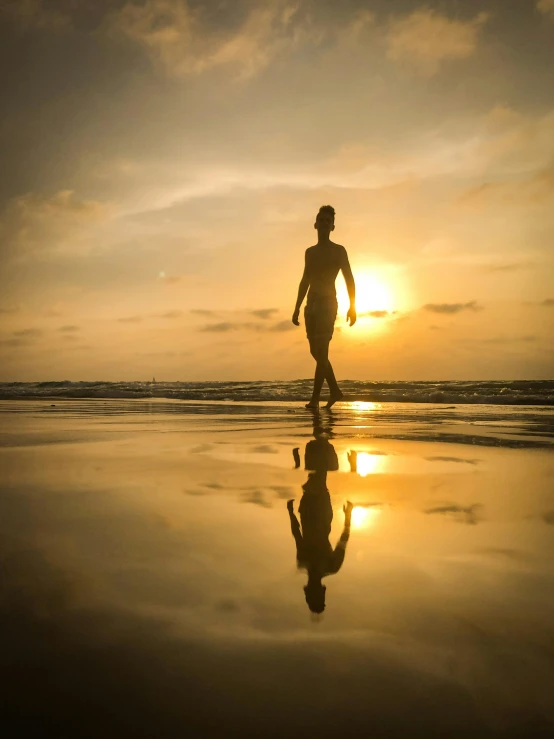 a person walking on a beach at sunset, in the ocean, profile image, bali, reflection