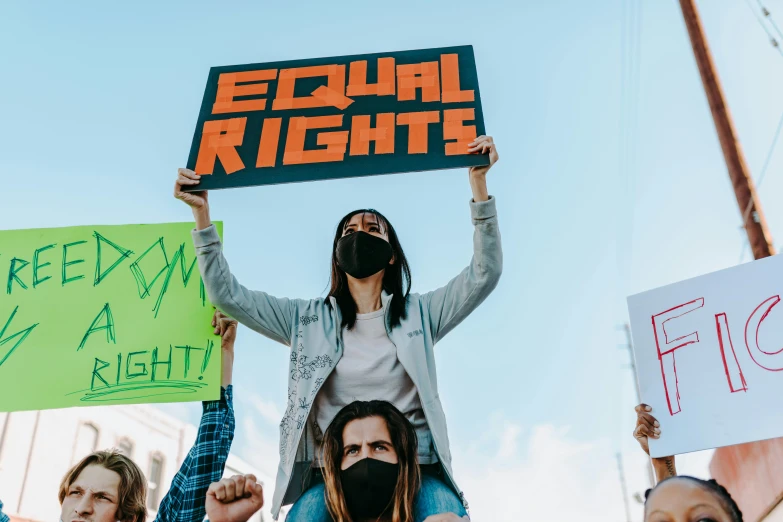 a group of people holding signs in the air, trending on pexels, feminist art, background image, high gradient, fight, ethics