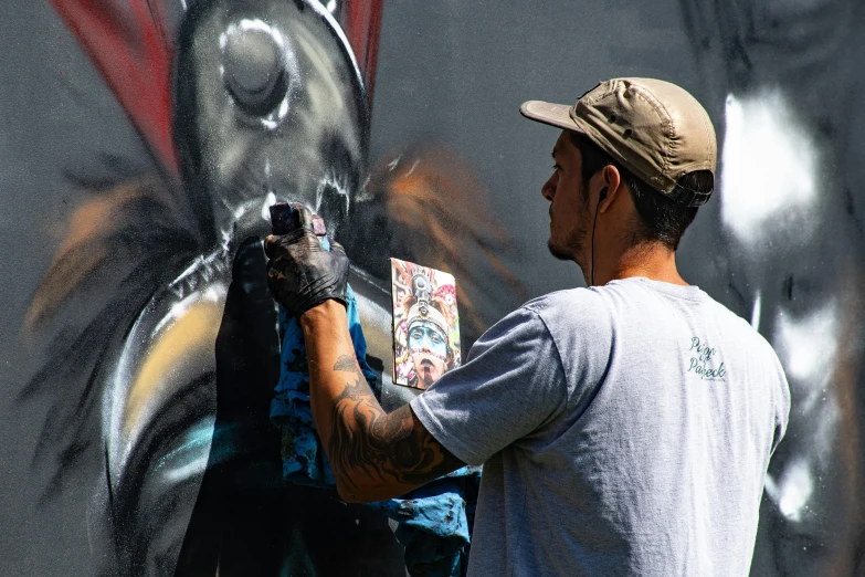 a man painting a mural on the side of a building, an airbrush painting, by Tom Bonson, pexels contest winner, profile image, people at work, black graffiti, on canvas