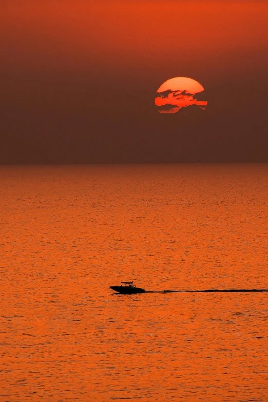 a boat in the middle of the ocean at sunset, by Ian Fairweather, photographed for reuters, gulf of naples, suns, grey