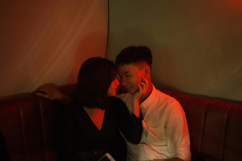 a man and a woman sitting on a couch, inspired by Nan Goldin, pexels contest winner, asian male, profile image, in a nightclub, lovely couple