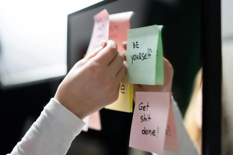 a person putting sticky notes on a computer screen, by Julia Pishtar, pexels, woman holding sign, motivational, instagram post, videogame still