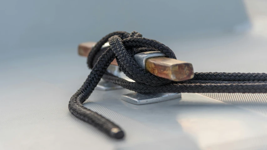 a close up of a rope on a boat, inspired by W. Lindsay Cable, unsplash, arabesque, black resin, metal handles, on grey background, sitting down