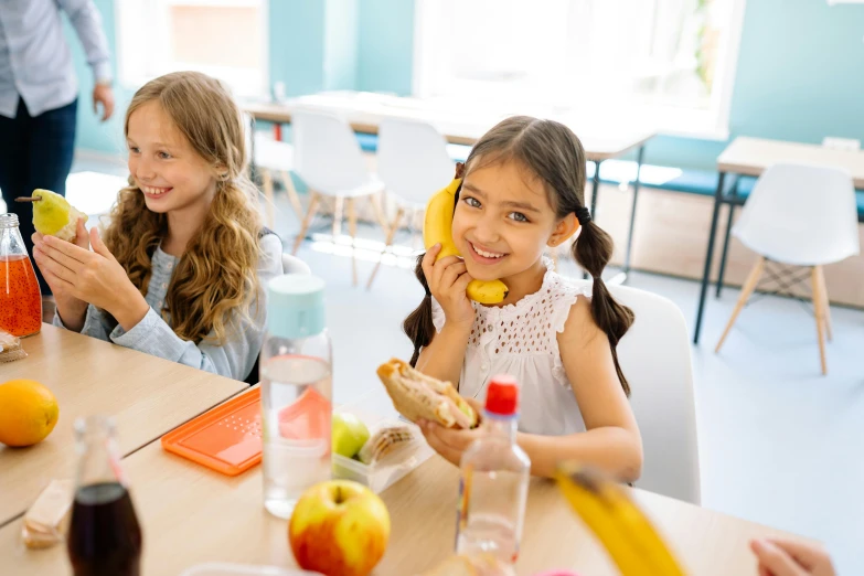 a group of children sitting at a table eating food, pexels contest winner, danube school, girl making a phone call, sitting in the classroom, lachlan bailey, bright day