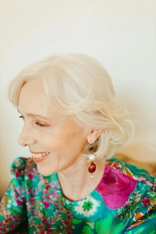 a woman sitting at a table with a plate of food, wearing pearl earrings, messy wavy white hair, jane clarke, profile image