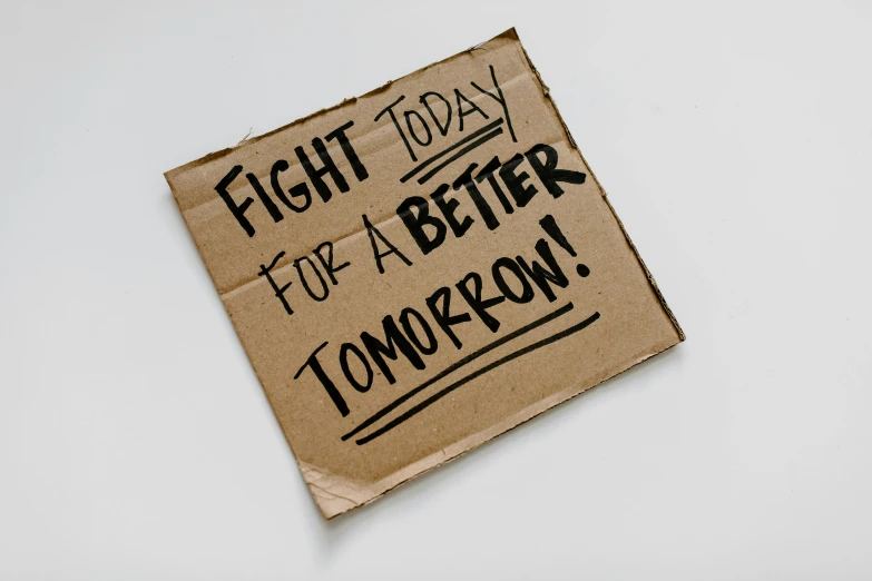 a cardboard sign that says fight today for a better tomorrow, by Julia Pishtar, effective altruism, instagram post, ilustration, taken with sony alpha 9