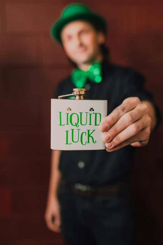 a man holding a flask with liquid luck written on it, profile image