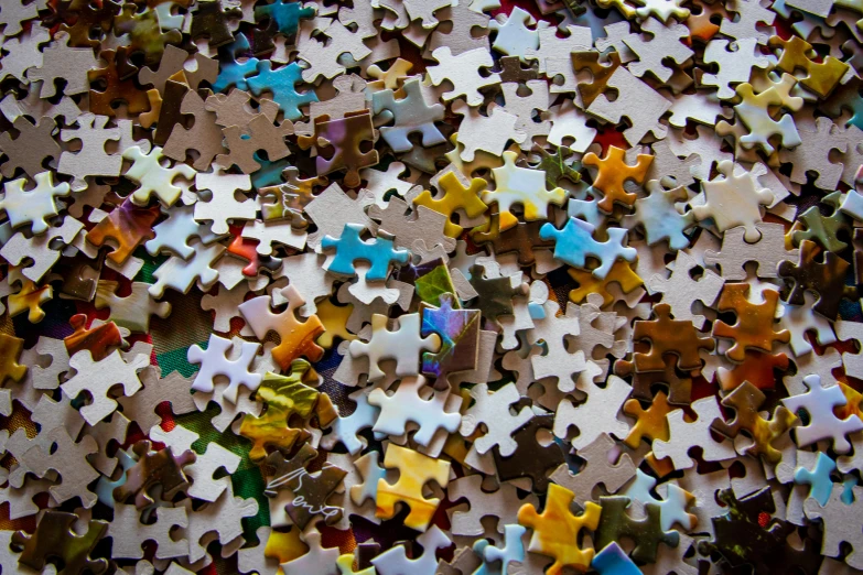 a pile of puzzle pieces sitting on top of a table, a jigsaw puzzle, by Daniel Lieske, pexels, 256x256, curiosities, tileable, taken in the late 2000s