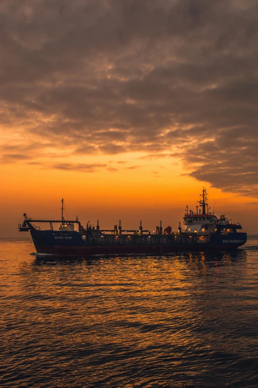 a large boat floating on top of a body of water, at the golden hour, night time, evening time, afar