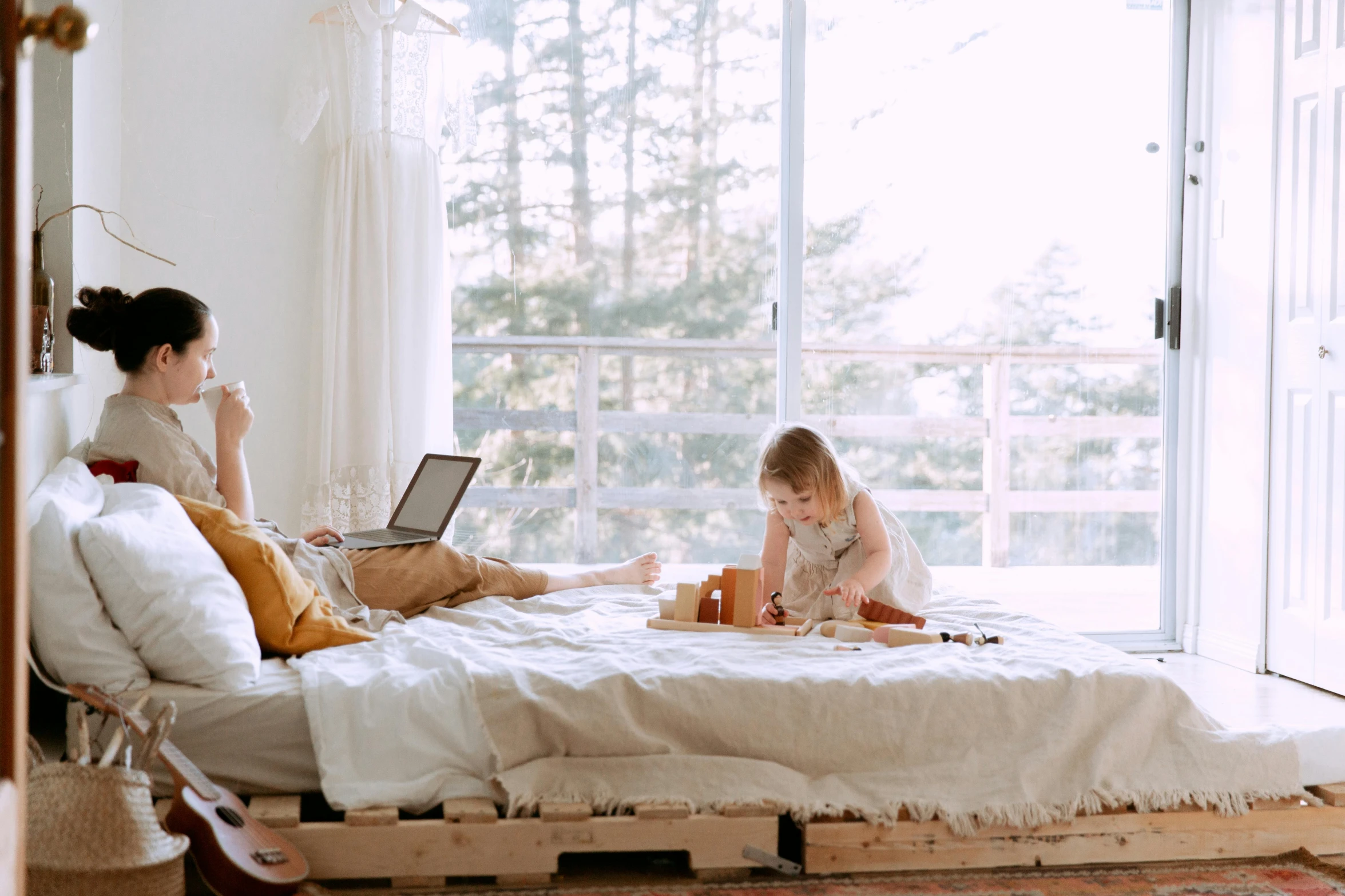 a woman and a little girl sitting on a bed, pexels contest winner, pallet, people at work, couple on bed, slightly sunny