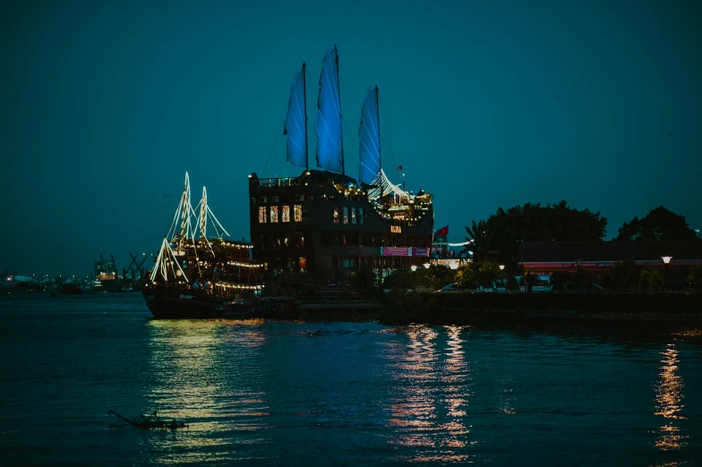 a boat that is sitting in the water, at night time, sailing ships, floating palace, cinematic photograph