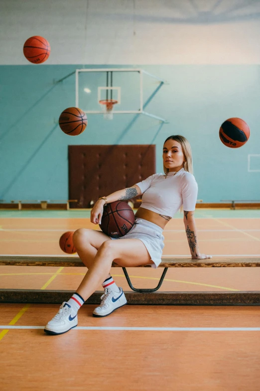 a woman sitting on a bench holding a basketball, by Matija Jama, trending on dribble, local gym, alexey egorov, legs spread, in the high school gym