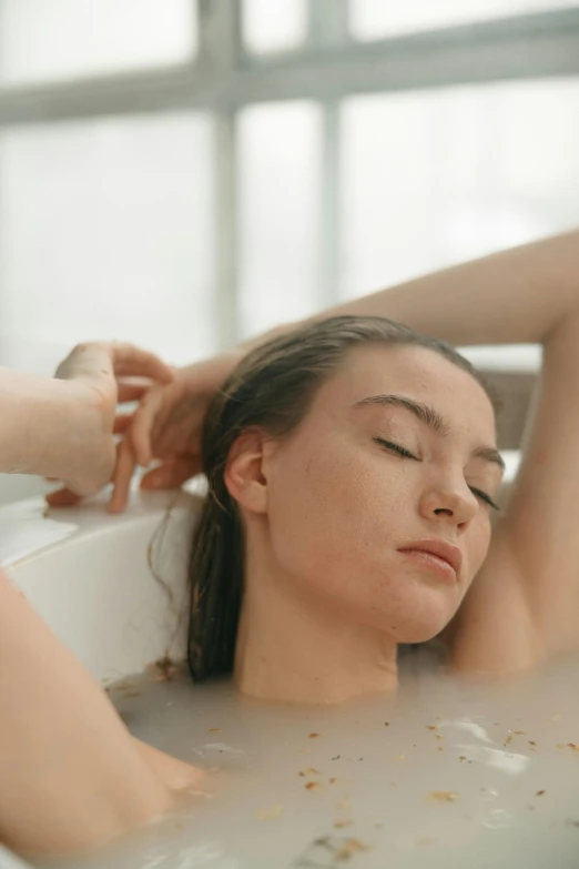a woman taking a bath in a bathtub, trending on pexels, her hair is tied above her head, sleepy, teenage girl, rippling