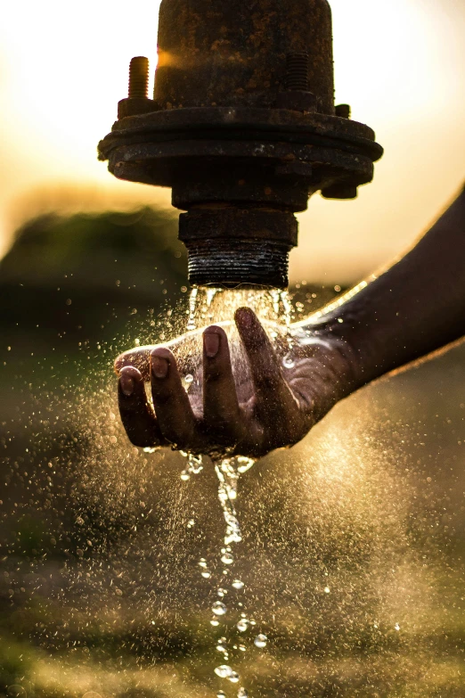 a person's hand is sprinkled with water from a fire hydrant, pexels contest winner, renaissance, golden hour sunlight, peacefully drinking river water, on a hot australian day, screensaver