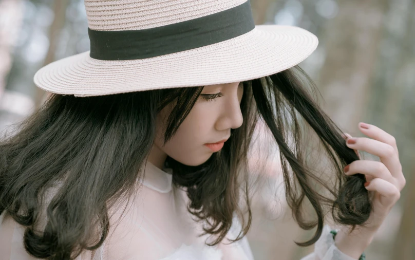 a close up of a person wearing a hat, inspired by Itō Shinsui, trending on pexels, teen girl, thoughtful ), white straw flat brimmed hat, asian girl with long hair
