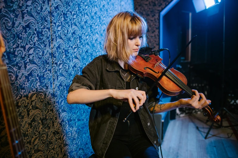 a woman that is playing a violin in a room, an album cover, unsplash, chloe price, in a studio hollow, panorama, a blond