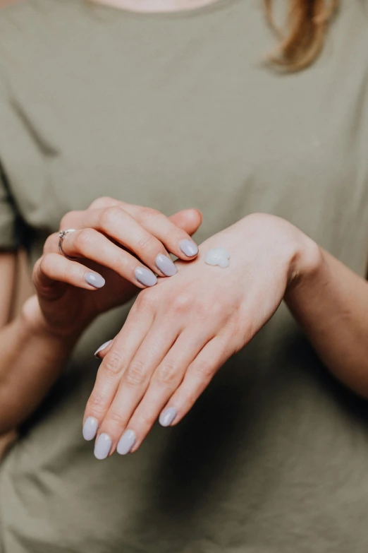 a woman putting cream on her hands, by Adam Marczyński, pexels, renaissance, square, low detailed, silicone skin, half image