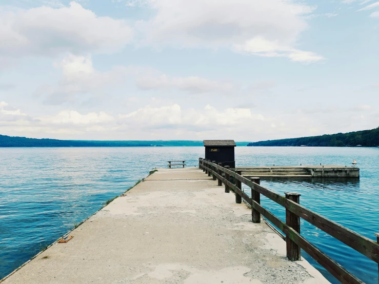 a pier in the middle of a large body of water, a picture, unsplash, mingei, cornell, split near the left, well list, lake in the background