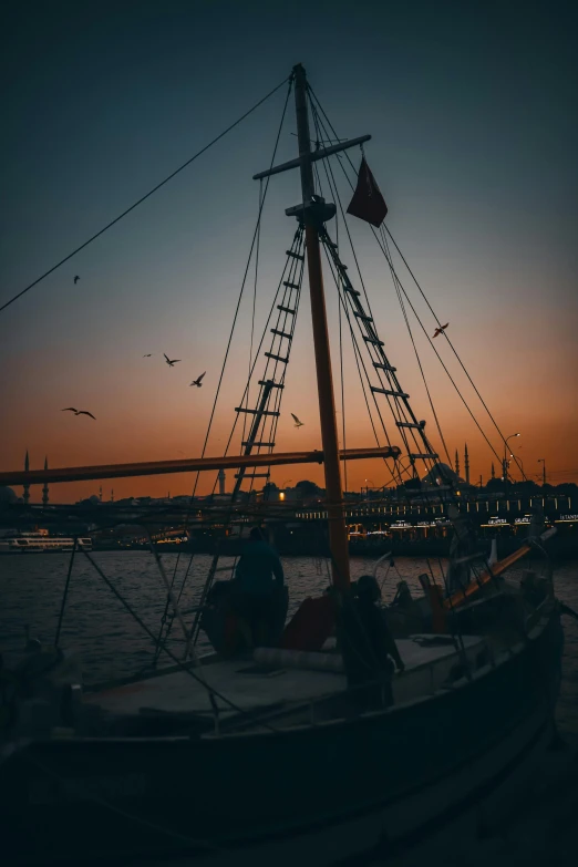 a boat sitting on top of a body of water, by Jan Tengnagel, pexels contest winner, romanticism, three masts, low light cinematic, harbor, low quality photo