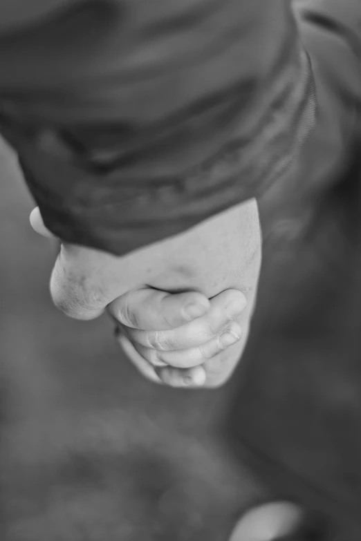 a black and white photo of a person holding a tennis racquet, a black and white photo, unsplash, holding each other hands, closeup of fist, wandering, hugging each other