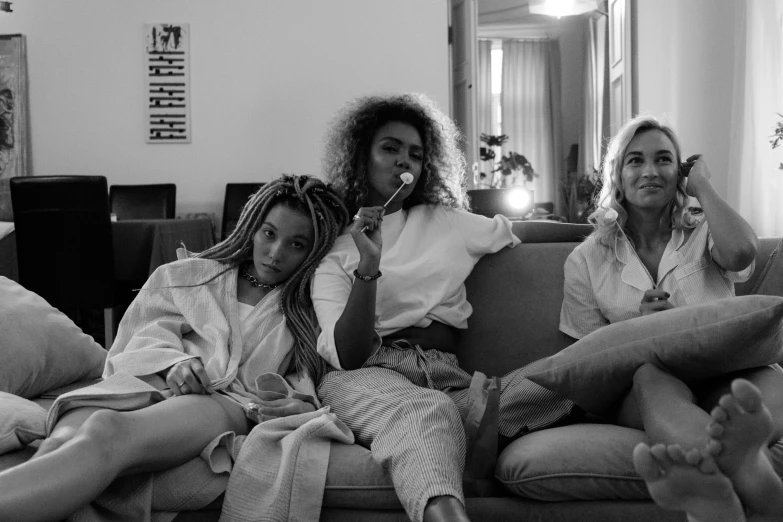 a black and white photo of three women sitting on a couch, by Emma Andijewska, ashteroth, wearing white pajamas, florence pugh, breakfast