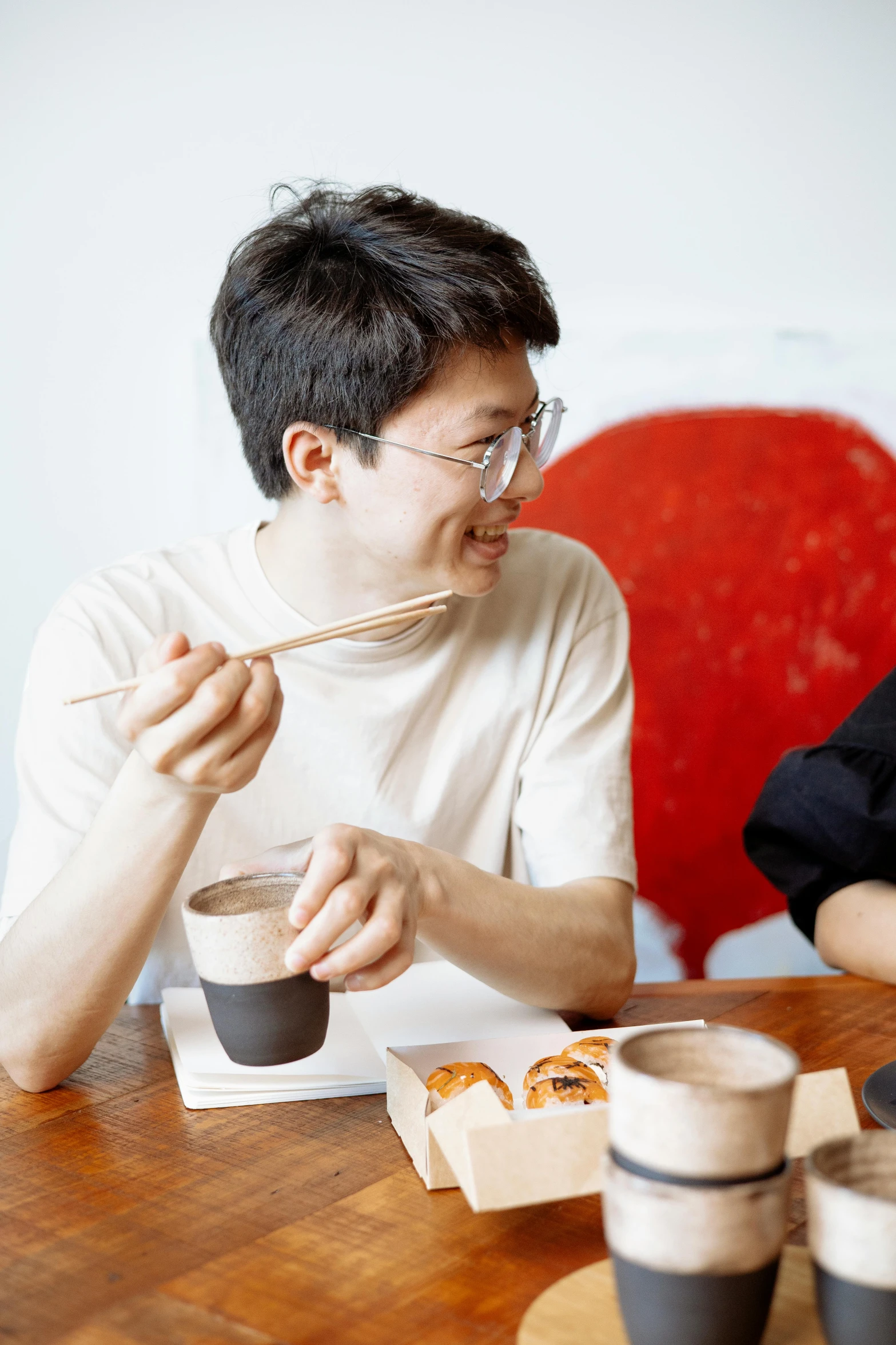 a couple of people that are sitting at a table, by Tan Ting-pho, celebration of coffee products, chopsticks, south korean male, slightly smirking