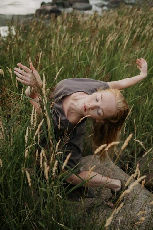 a little girl that is laying down in the grass, by Elizabeth Polunin, renaissance, contemporary dance, tilda swinton, standing in tall grass, spiritual scene