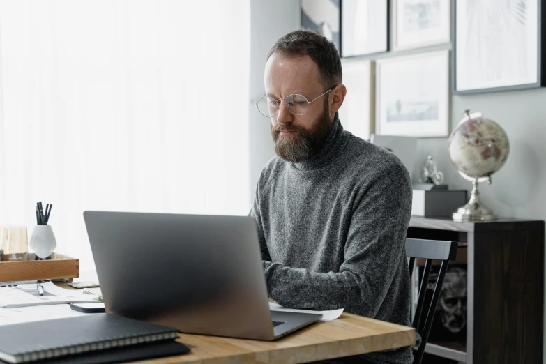 a man sitting at a desk using a laptop computer, pexels contest winner, grey trimmed beard, lachlan bailey, doug walker, modern casual clothing