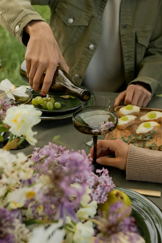 a group of people sitting at a table with plates of food, rich vines and verdant flowers, olive oil, lifestyle, grey