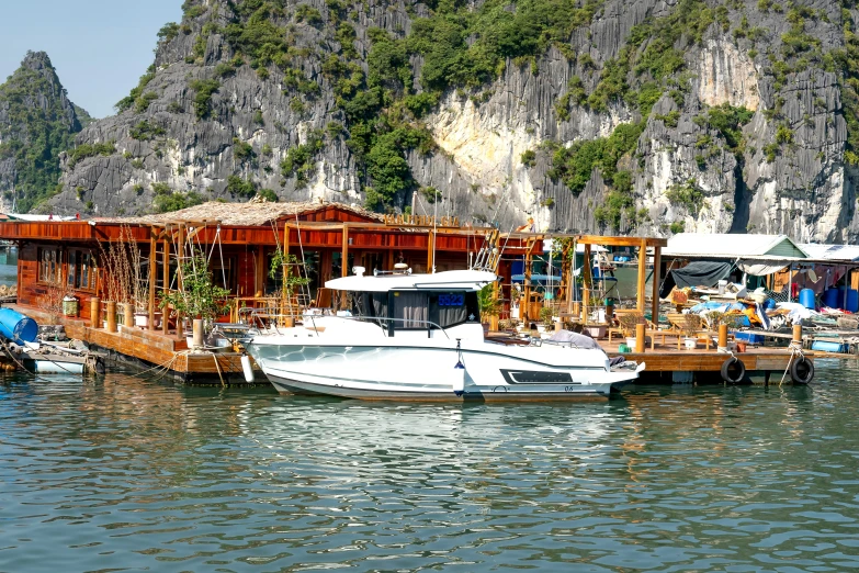 a number of boats in a body of water, pexels contest winner, restaurant in background, phong shaded, limestone, bao pham