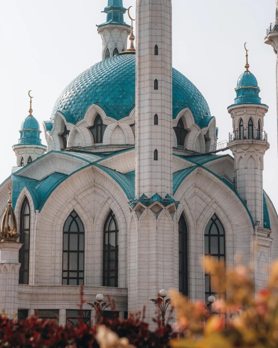 a large white and blue building with a clock tower, a colorized photo, unsplash contest winner, art nouveau, he is in a mosque, wearing teal beanie, kazakh empress, gif