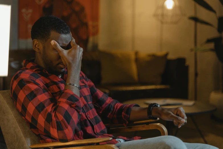 a man sitting in a chair talking on a cell phone