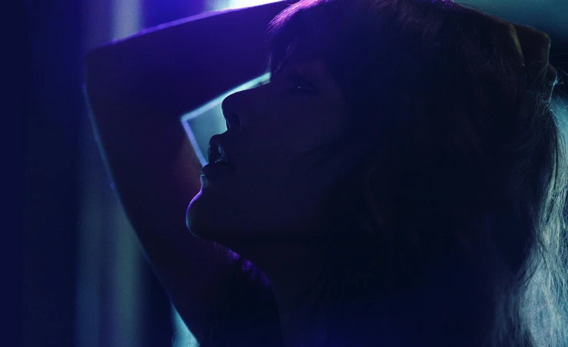 a woman standing in front of a purple light, inspired by Nan Goldin, pexels, realism, with bangs, sensual woman, sza, silhouetted